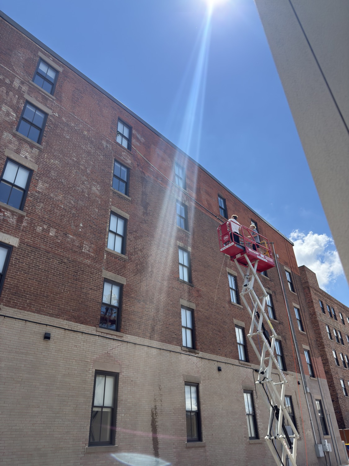 Commercial window washing on a multi-story brick building